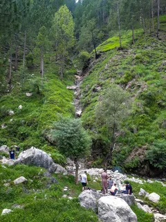 Harnoi Wasserfall mit Gruppe Menschen am felsigen Hang in Abbottabad, Pakistan