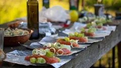 Holztisch mit Tellern voller Essen, warme Mahlzeiten typisch österreichisch