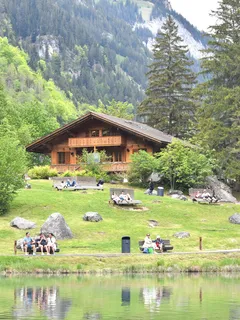 Gruppe sitzt auf Bank vor einem See im Freien