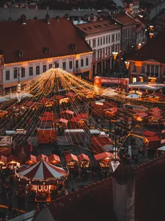 Luftaufnahme eines Weihnachtsmarkts bei Nacht mit festlicher Beleuchtung